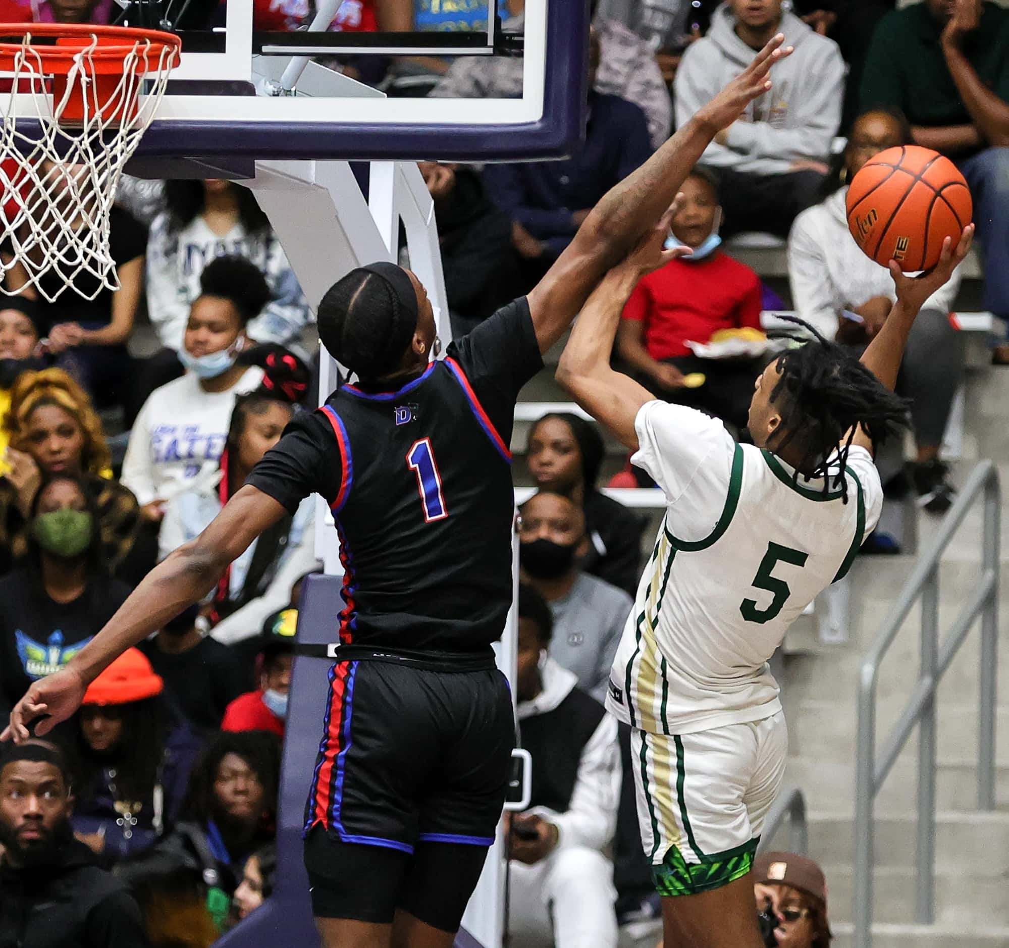 Duncanville forward Ron Hollard (1) gets a block on DeSoto forward Ahmir Wall (5) during the...