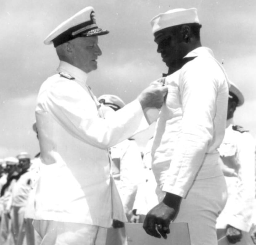 Admiral C. W. Nimitz, the commander in chief, Pacific Fleet, pins the Navy Cross on Doris...