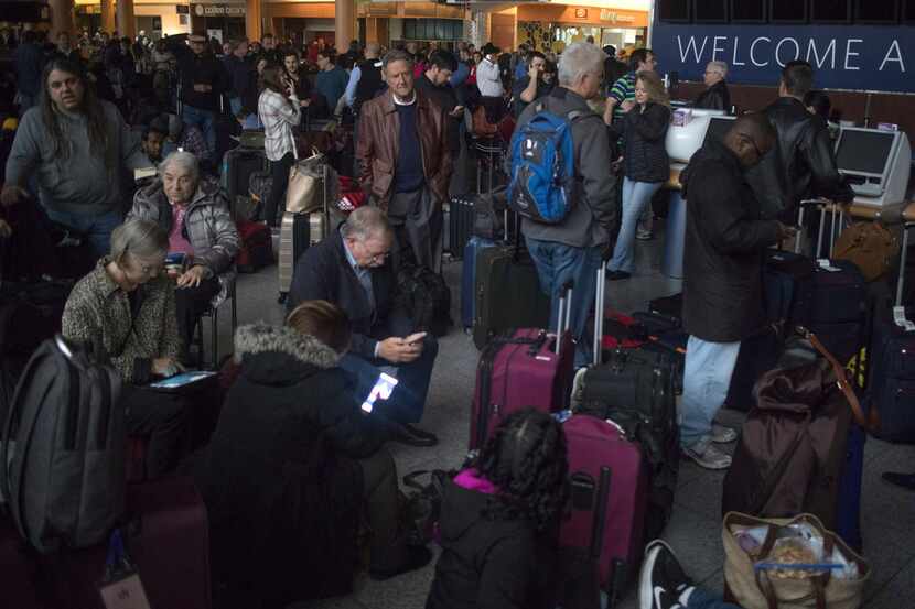Passengers wait in a dark terminal at Hartsfield-Jackson International Airport, Sunday, Dec....