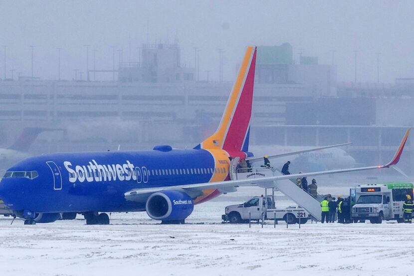 Passengers exit Southwest Airlines flight 1643 after the plane slid off the runway at Eppley...