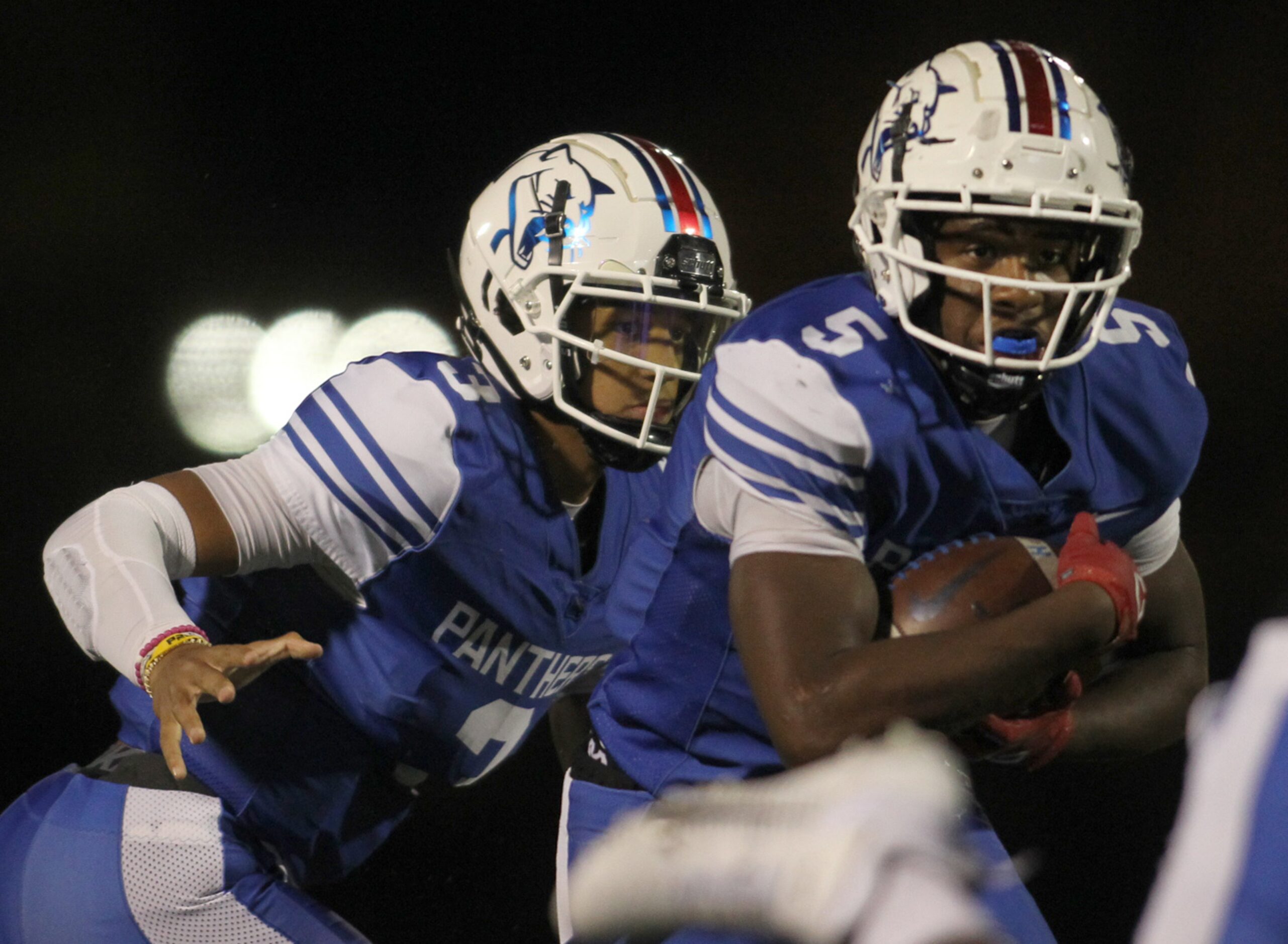 Duncanville quarterback Grayson James (3) hands off to running back Malachi Medlock (5) for...