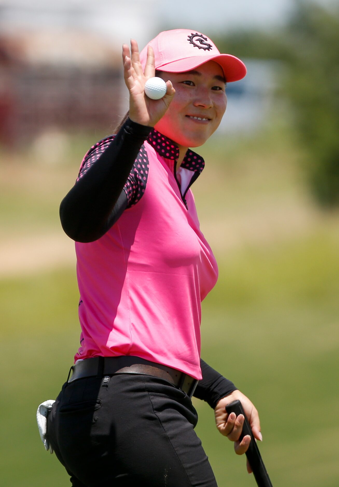 Professional golfer Min-G Kim waves to the crowd after making par on the 18th hole during...