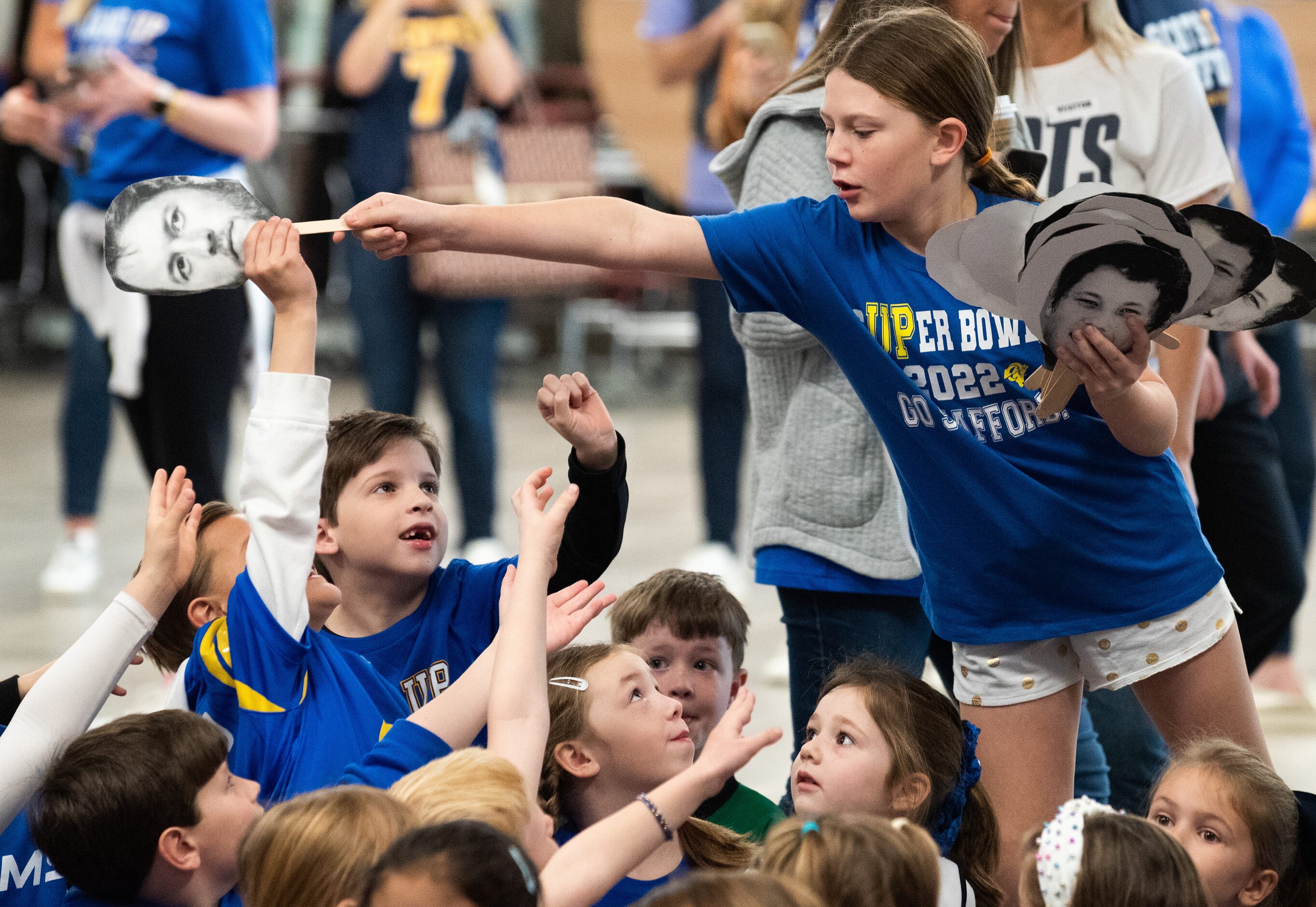 Fourth grader Harper Logan, right, passes photo cut-outs of Matthew Stafford to first...