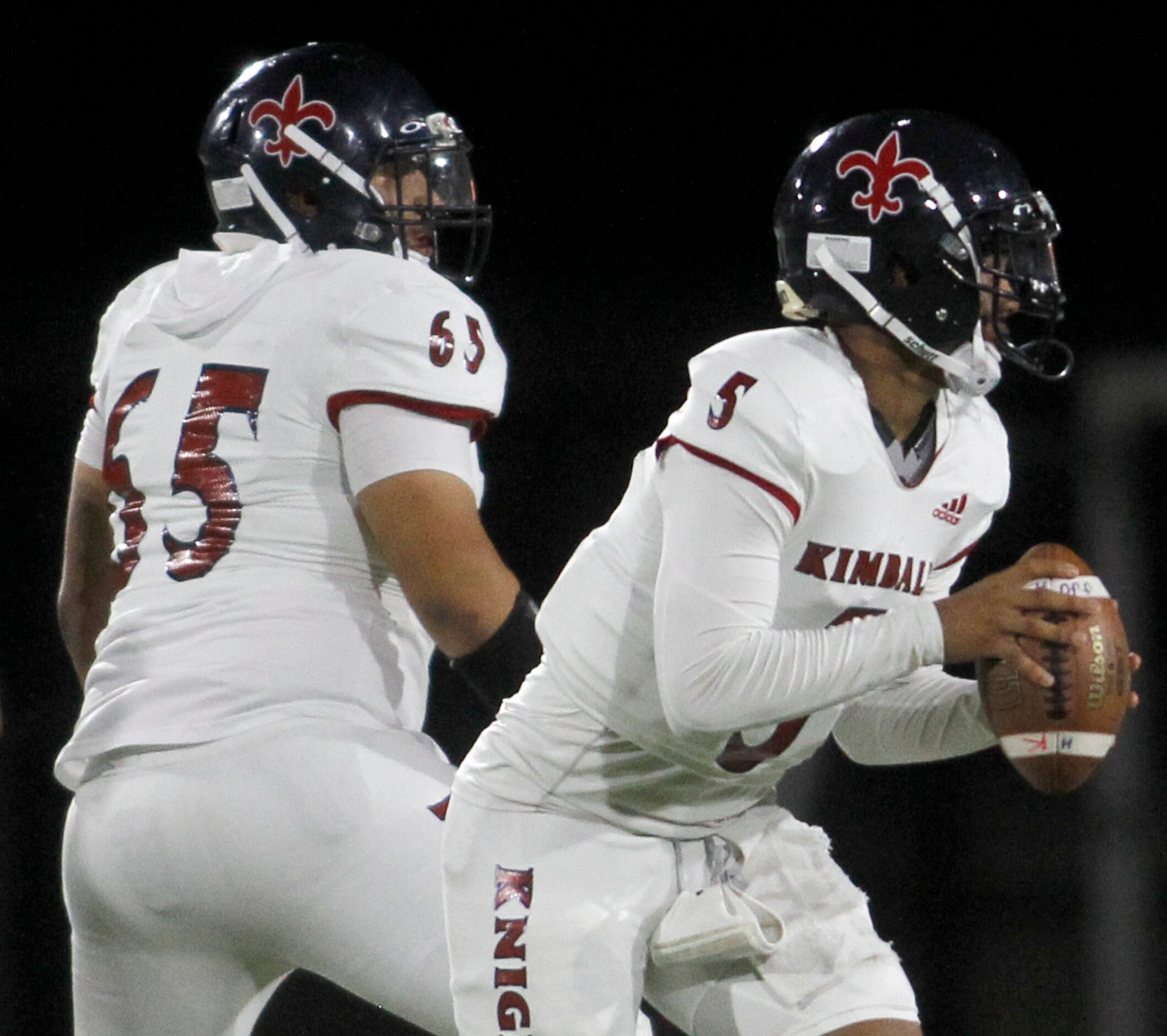 Dallas Kimball quarterback Jacarion Sauls (5) rolls out to pass behind the protection of...