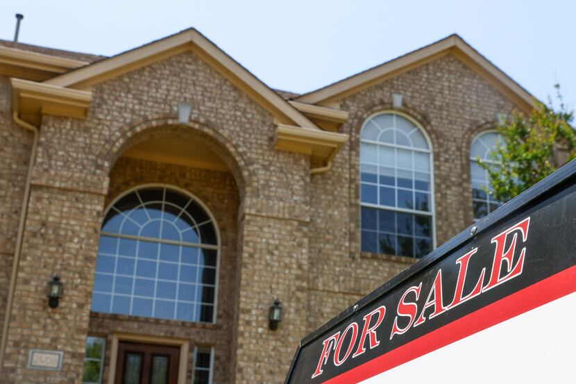 A for sale sign is displayed outside of a house in Plano in June. The local median...