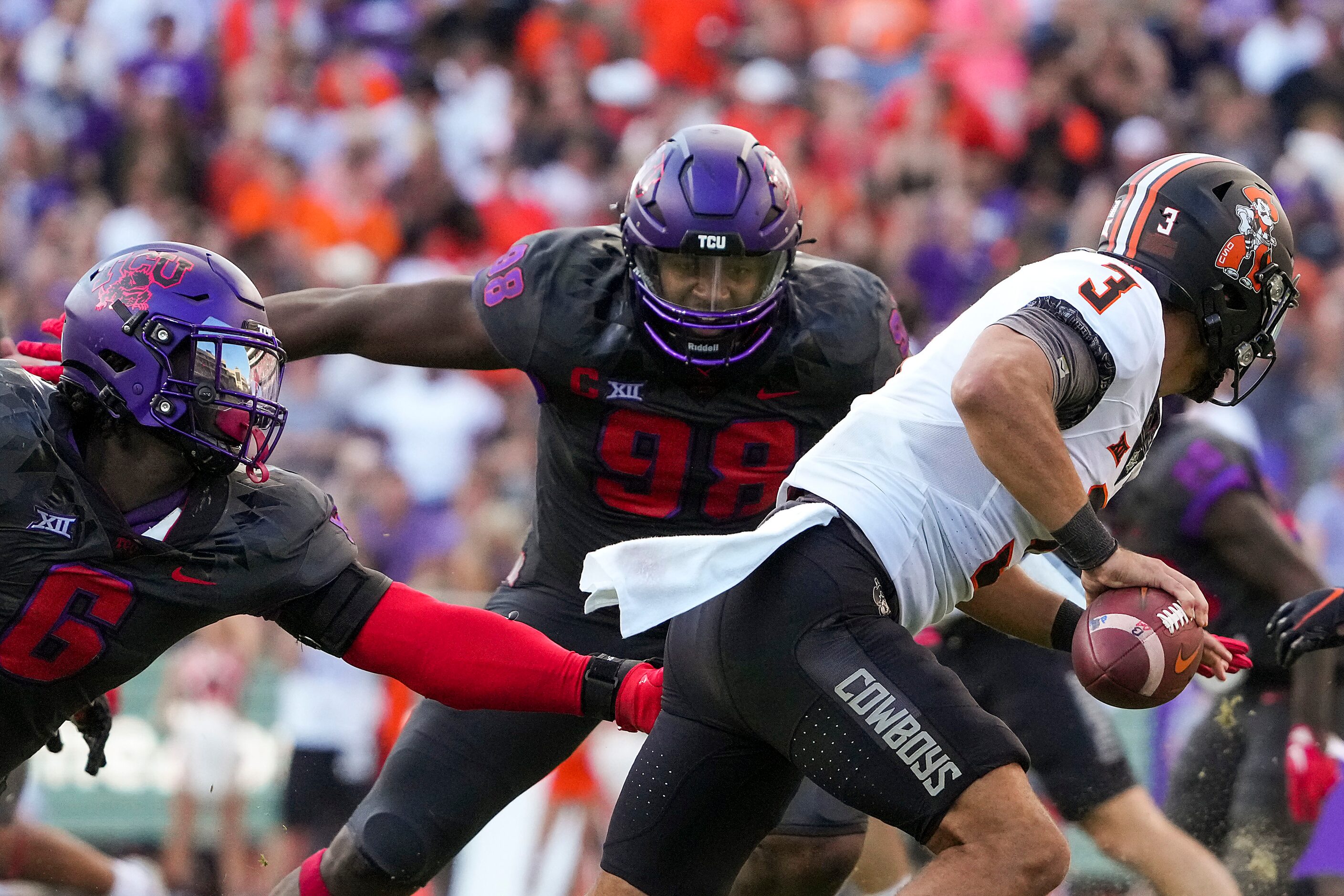 Oklahoma State quarterback Spencer Sanders (3) is flushed from the pocket by TCU linebacker...