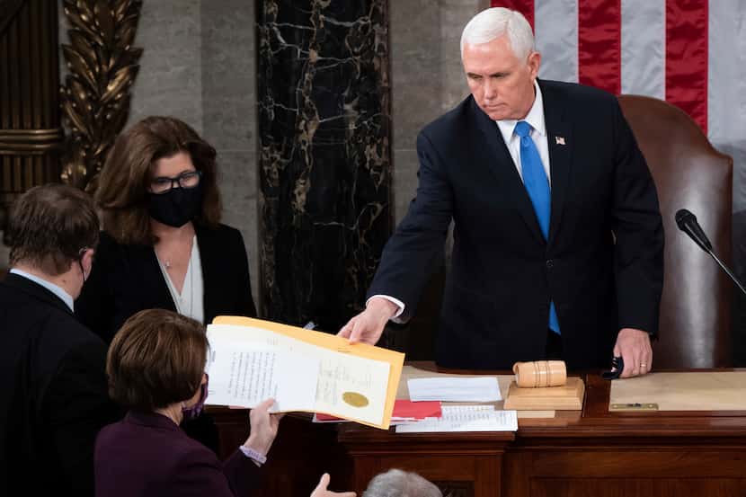 Former Vice President Mike Pence hands the electoral certificate from the state of Arizona...