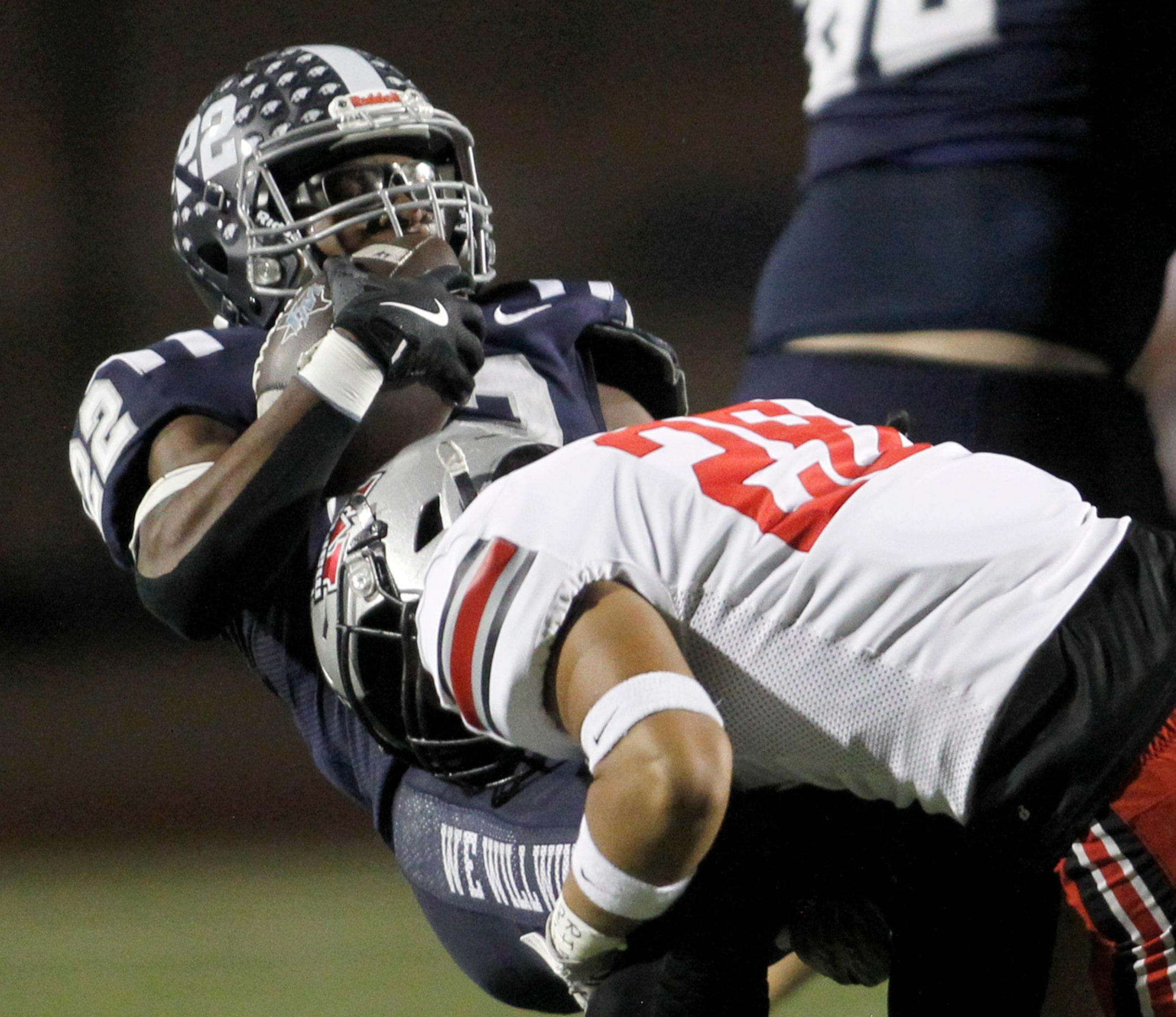 Flower Mound running back Marcus Simpson (22), left, is stopped at the line of scrimmage by...