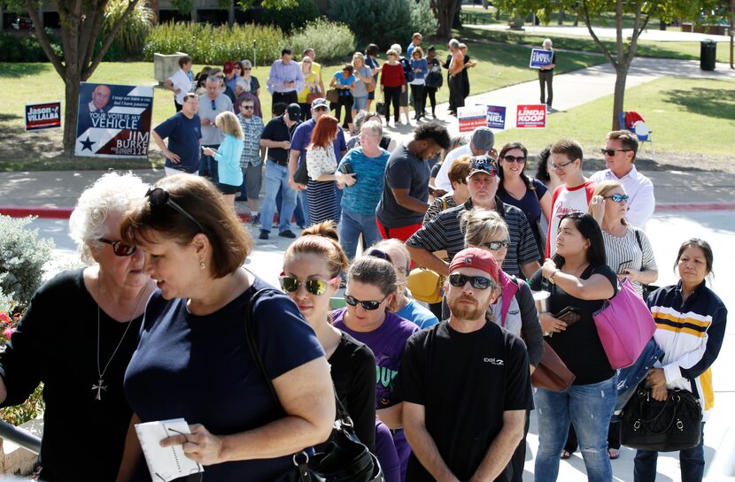 People wait in line to vote at Fretz Park Dallas Public Library in Dallas on Monday, October...