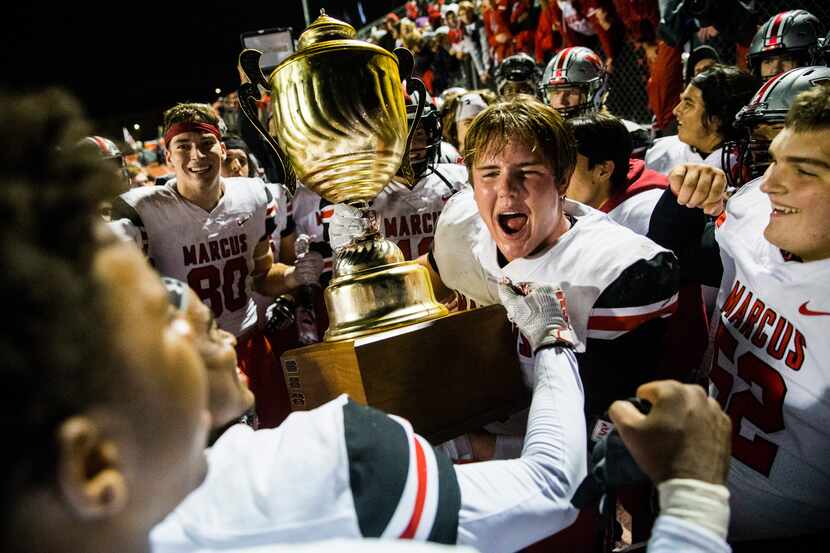 Flower Mound Marcus linebacker Michael Carignan (5) hoists the Mound Showdown trophy after a...