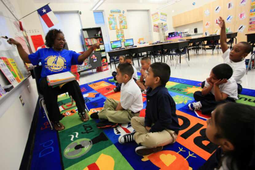 First-grade teacher Tiffany Hardy works with students during a grammar lesson on their first...
