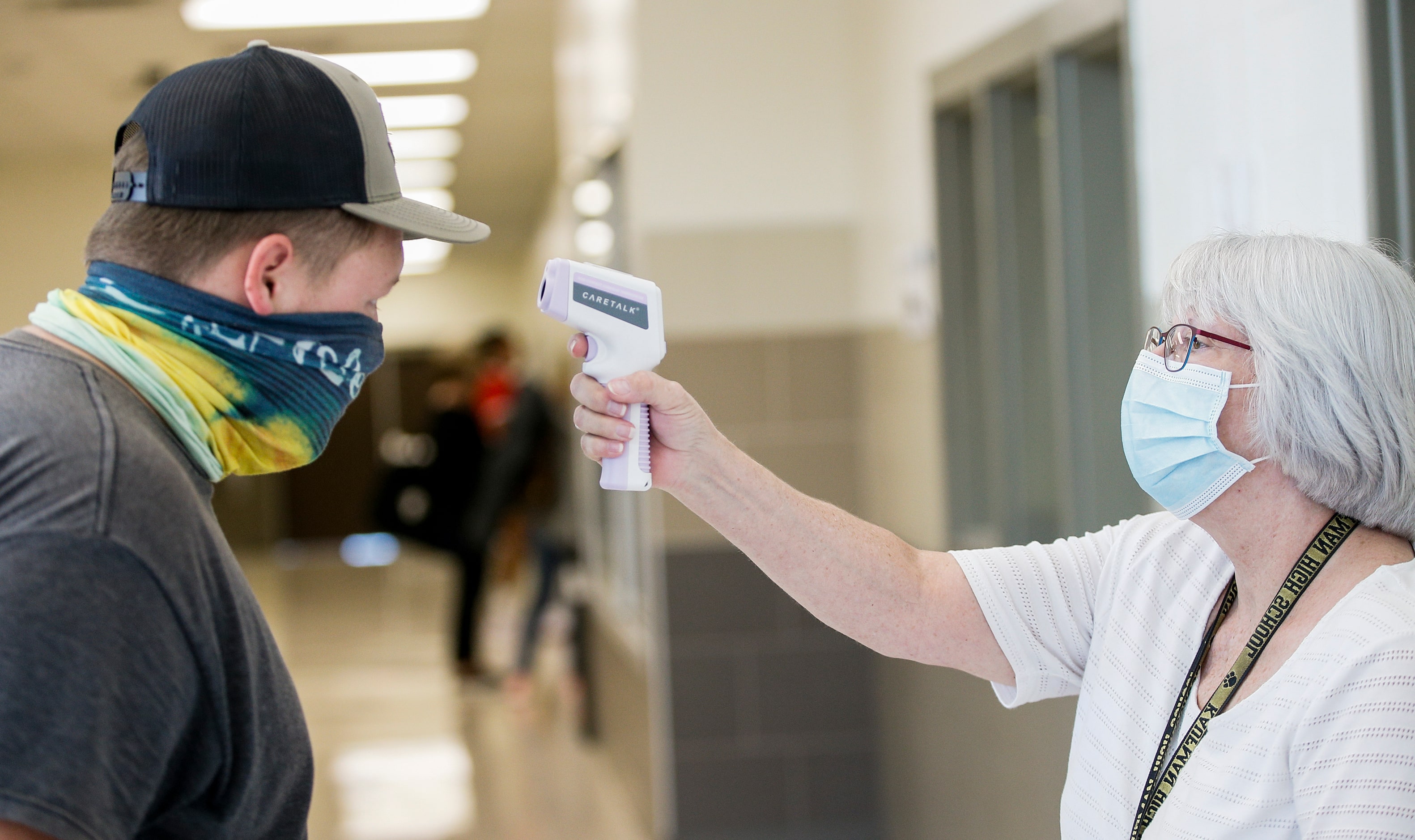 Theresa Francis, right, checks Cannon CarterÕs temperature upon entry to a high school...