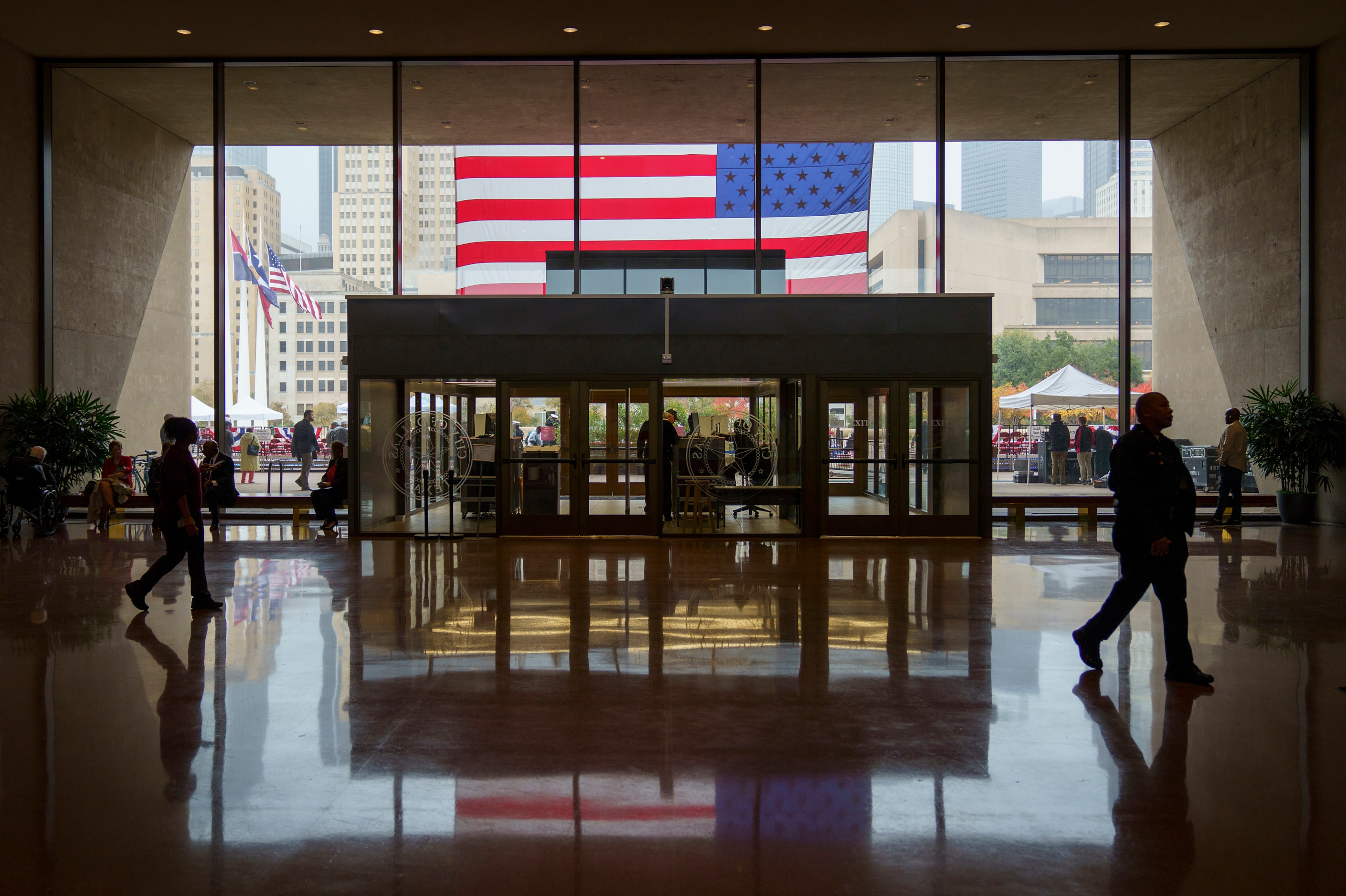 A large American flag hangs over the entrance to City Hall during The Greater Dallas...