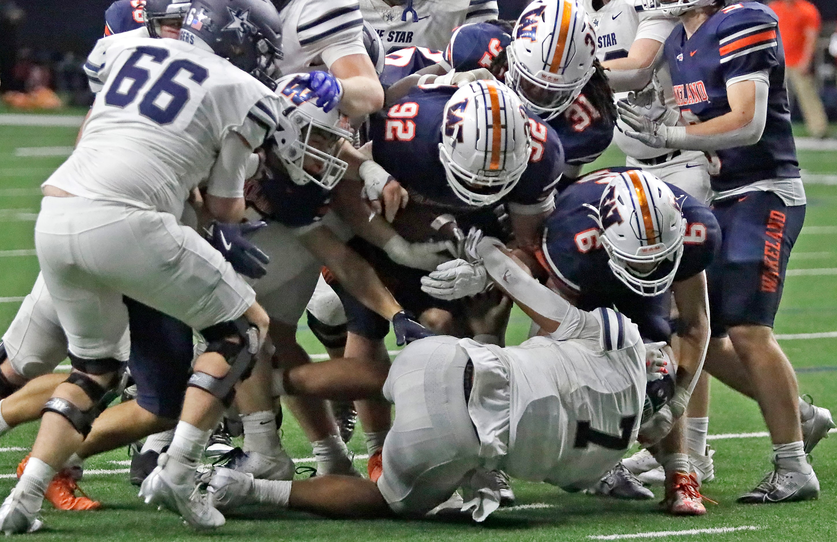 Wakeland High School defensive lineman Austin Wilson (92) strips Lone Star High School...