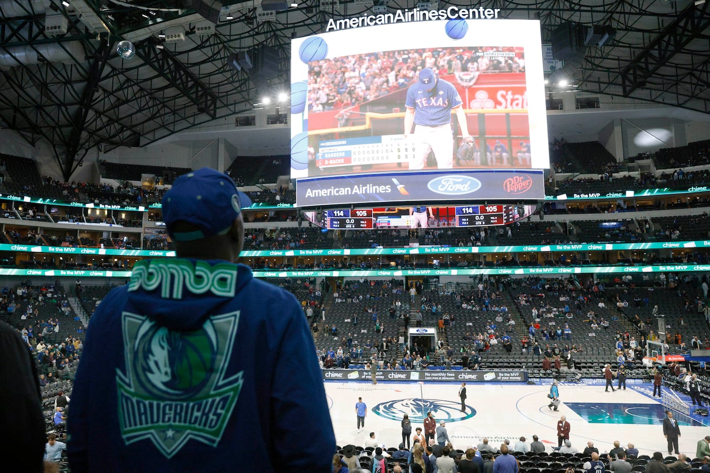 A Dallas Mavericks fan watches the ninth inning of the World Series on the Jumbotron after...