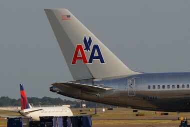  A Delta Air Lines jet passes an American Airlines airplane last month at Dallas/Fort Worth...