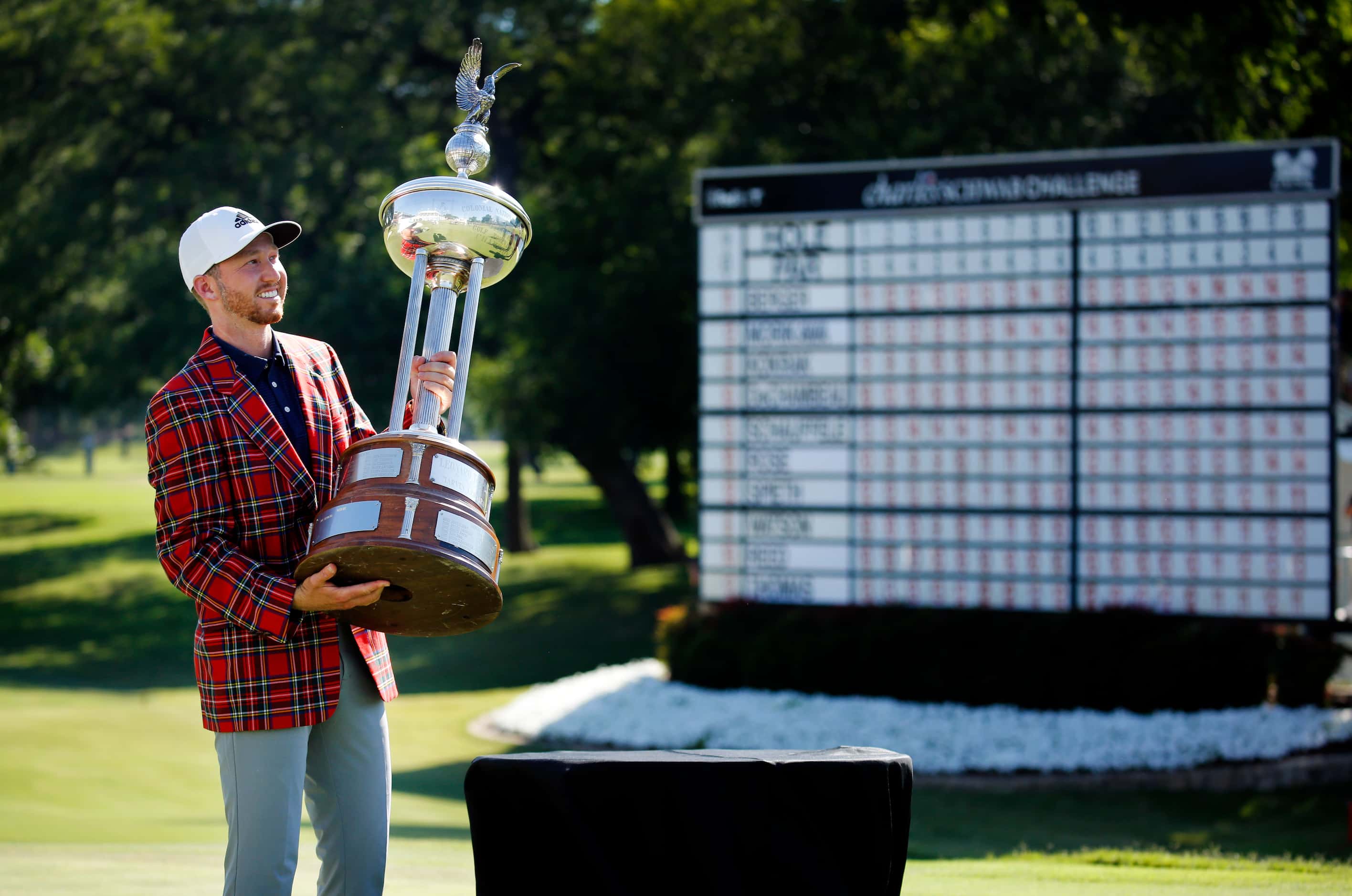 On the 18th green, PGA Tour golfer Daniel Berger poses with in the Leonard Trophy after...