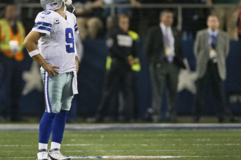 Dallas Cowboys quarterback Tony Romo (9) watches the replay of the final interception on the...