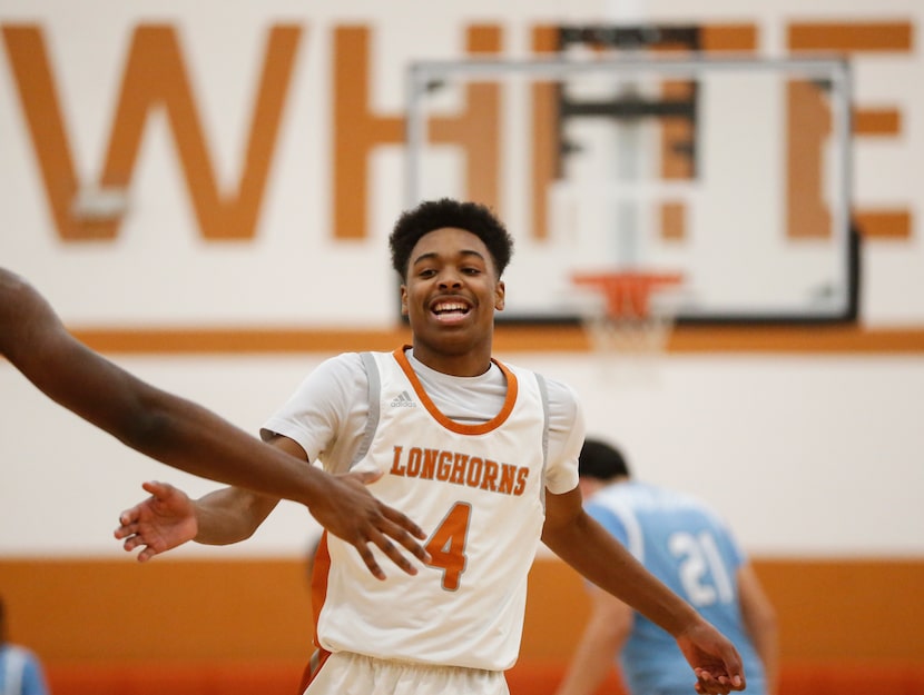 W.T. White High School guard Jamar Bates (4) high fives a team mate during the second...