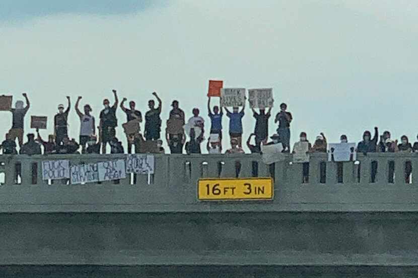 Dozens of protestors gathered on Center Street Bridge near Arlington s Highlands on June 1,...