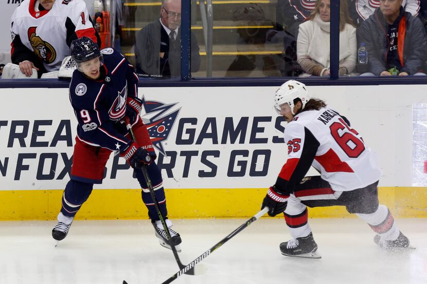 Columbus Blue Jackets forward Artemi Panarin, left, of Russia, passes the puck against...
