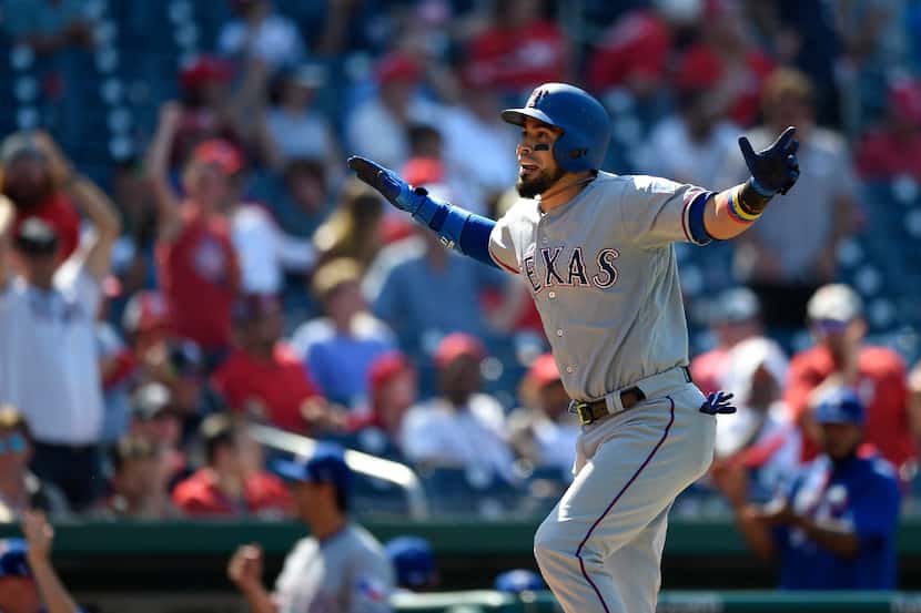 Texas Rangers' Robinson Chirinos reacts as he heads home after he hit a three-run home run...