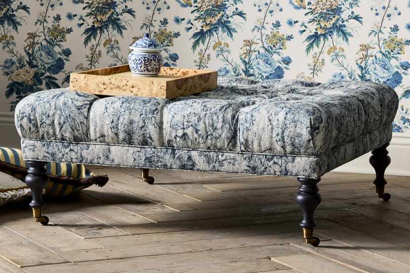 Tufted ottoman in a lively printed upholstery against a printed wallpaper