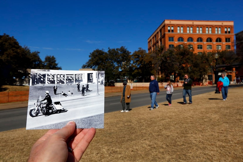 Tourists (right) gaze toward the grassy knoll at Dealey Plaza, Thursday, January  3, 2013,...