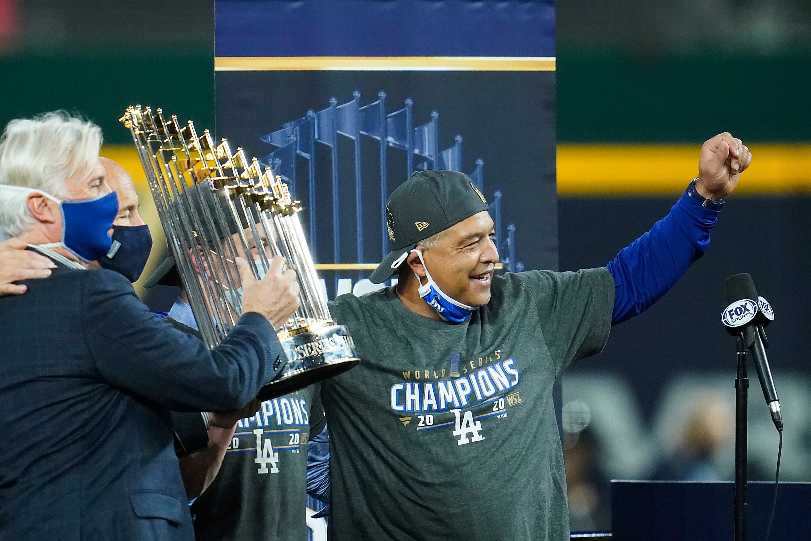 Los Angeles Dodgers manager Dave Roberts celebrates with the championship trophy after...