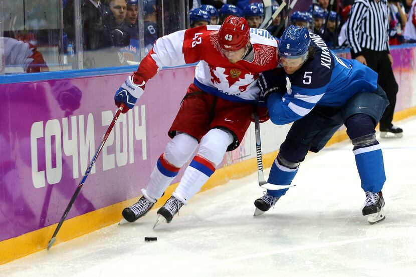 SOCHI, RUSSIA - FEBRUARY 19:  Lasse Kukkonen #5 of Finland challenges Valeri Nichushkin #43...