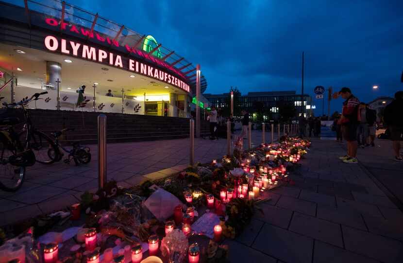 Candles and flowers in front of the Olympia-Einkaufszentrum shopping center in Munich on...