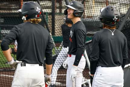 Argyle freshman Grady Emerson (center) laughed as he waited for batting practice alongside...