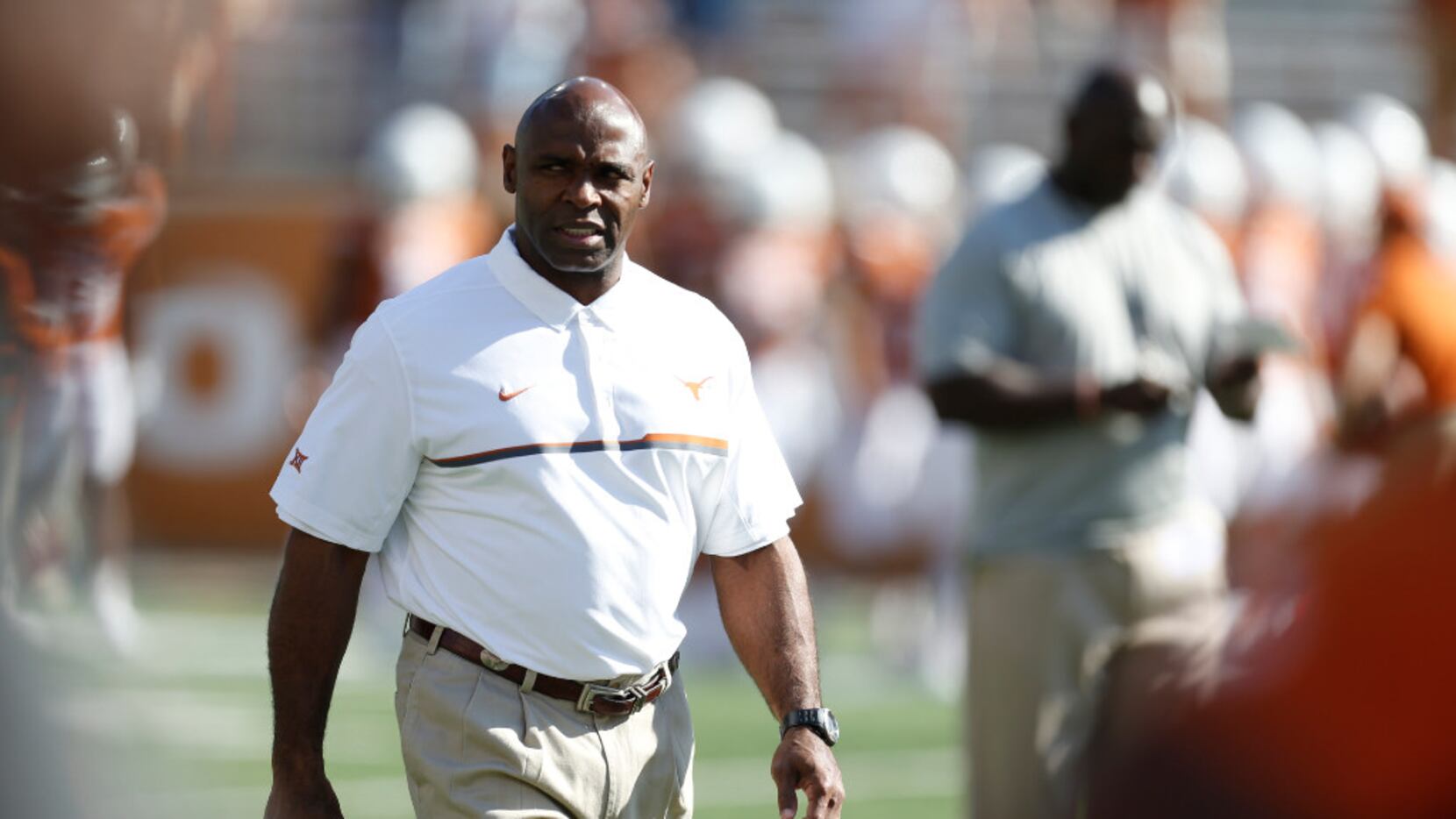 Texas Longhorns coach Charlie Strong watches his team during warm ups against West Virginia...