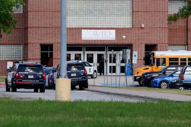 Several Arlington Police cars can be seen outside Arlington ISD's Bowie High School Wed.,...
