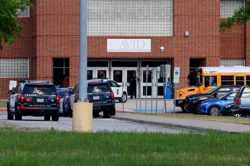 Several Arlington Police cars can be seen outside Arlington ISD's Bowie High School Wed.,...