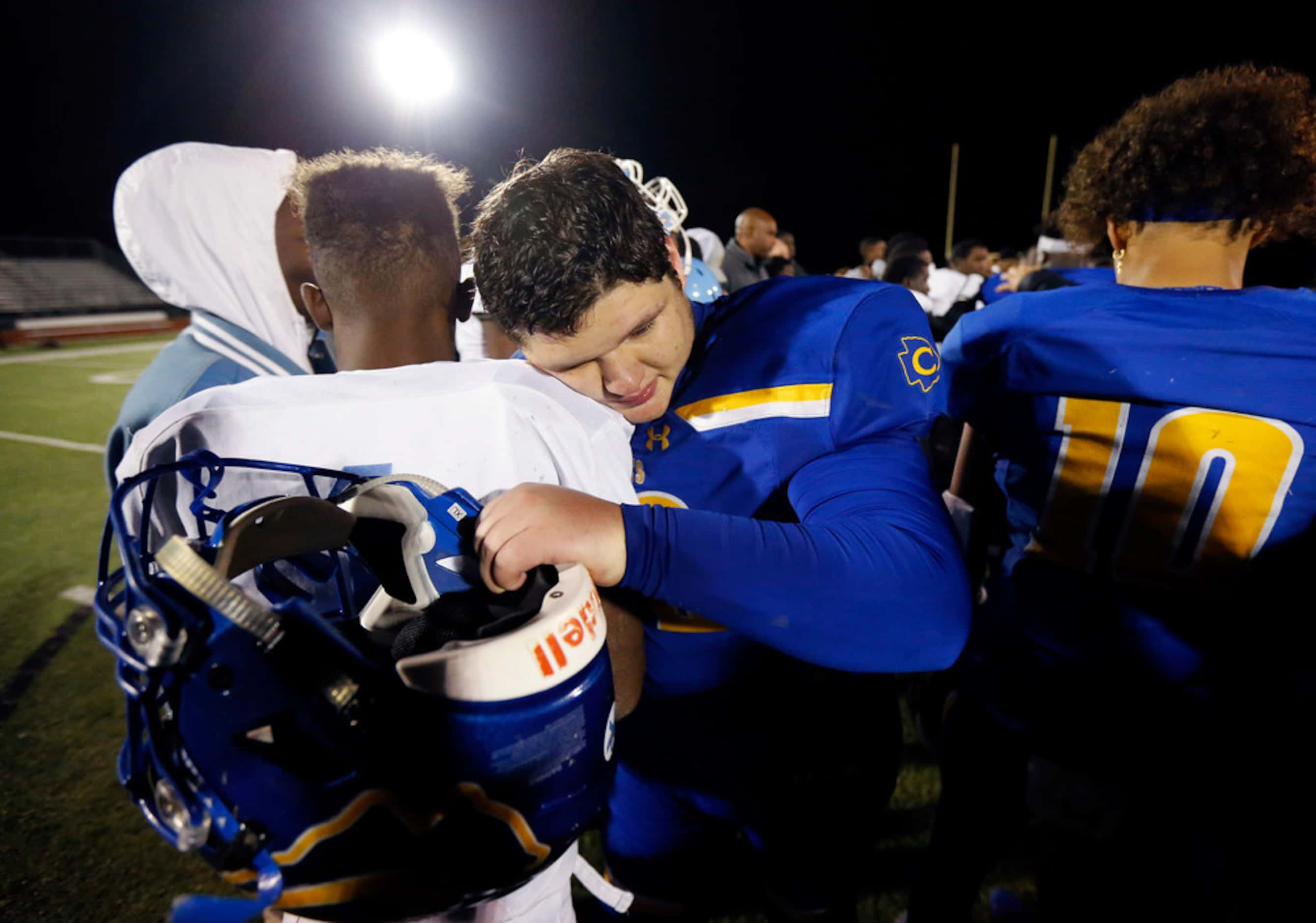 Community High football captains Eli Hartley receives a hug from Dallas Roosevelt's Byron...