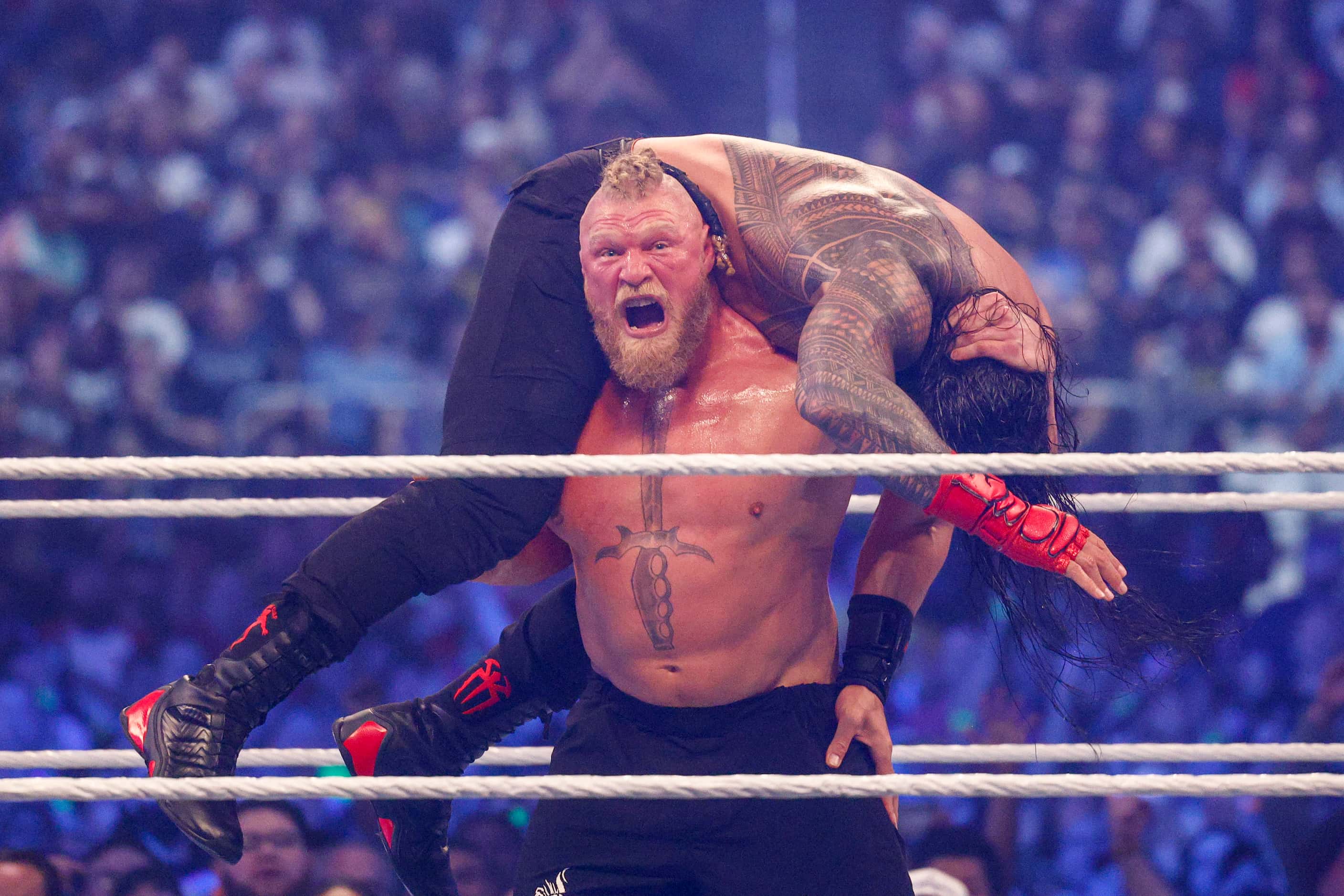 Brock Lesnar lifts Roman Reigns during a match at WrestleMania Sunday at AT&T Stadium in...