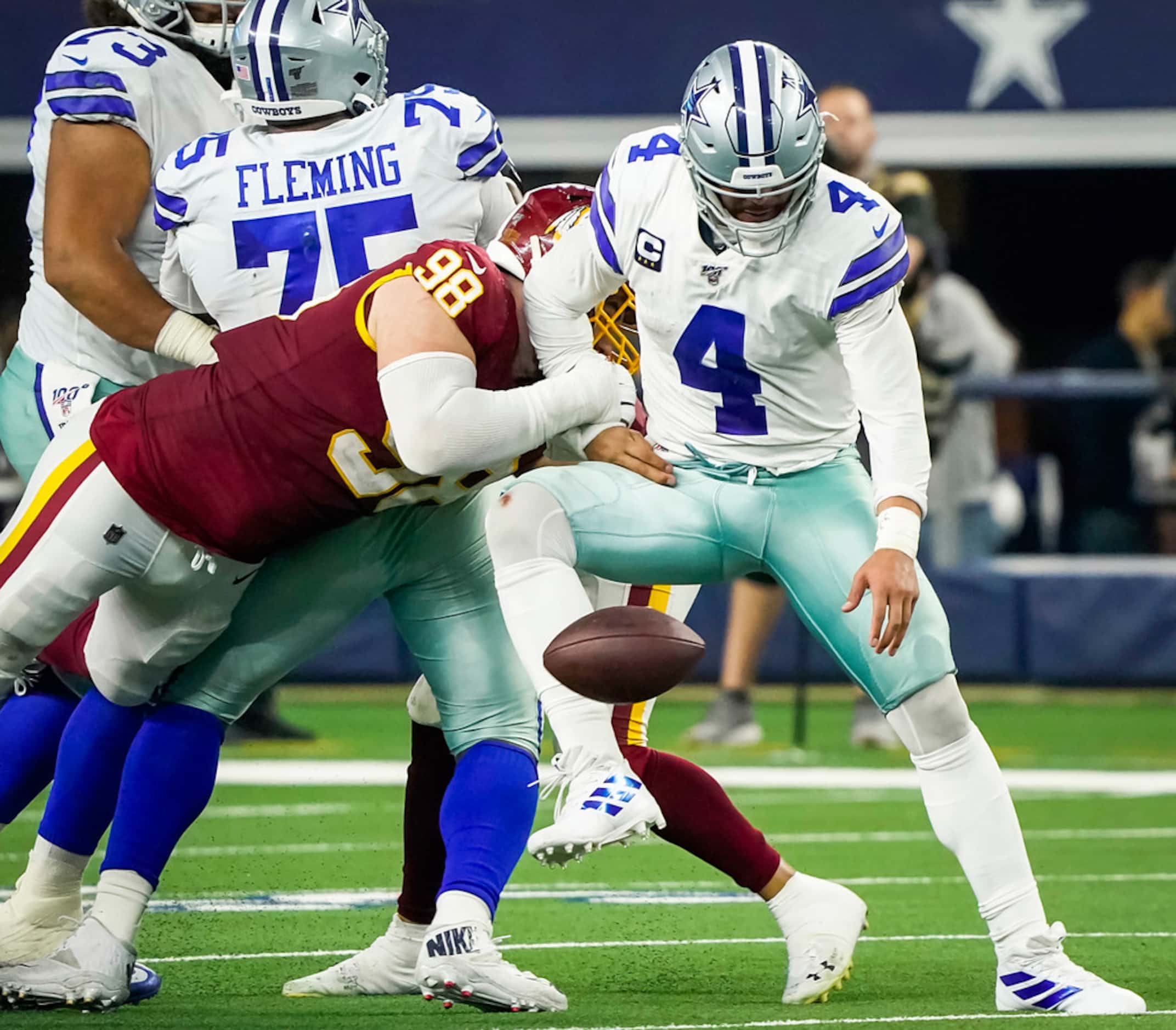 Dallas Cowboys quarterback Dak Prescott (4) fumbles as he is hit by Washington Redskins...