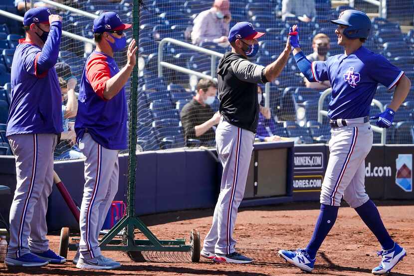 Texas Rangers outfielder Eli White (right) celebrates with manager Chris Woodward after...