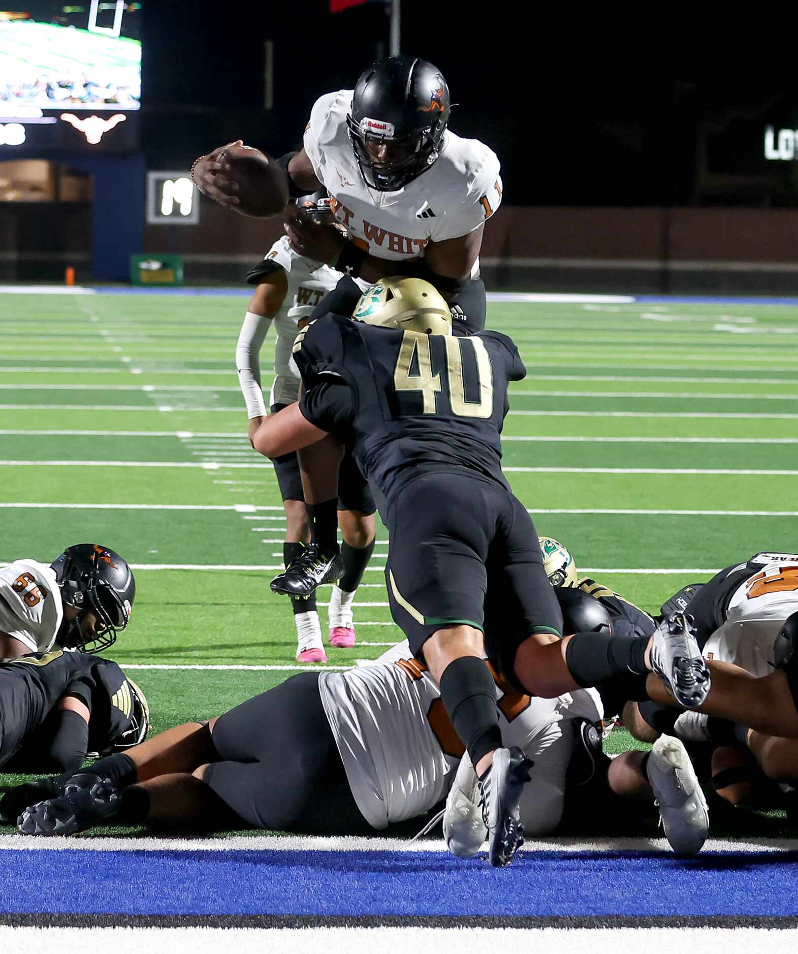 W.T. White running back Markavious Justice (11) goes over the top of Birdville defensive...