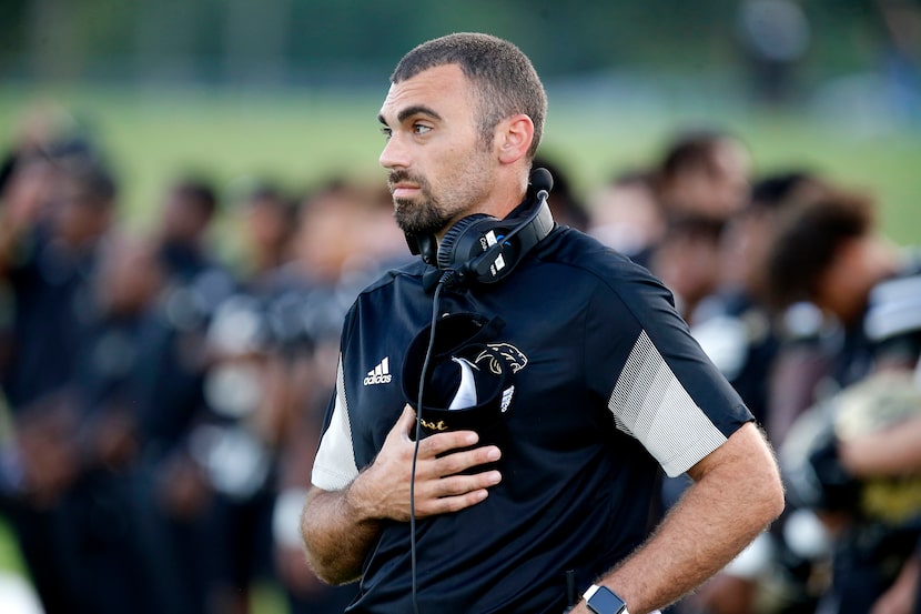 Plano East Senior High School head coach Tony Benedetto stands for the national anthem...