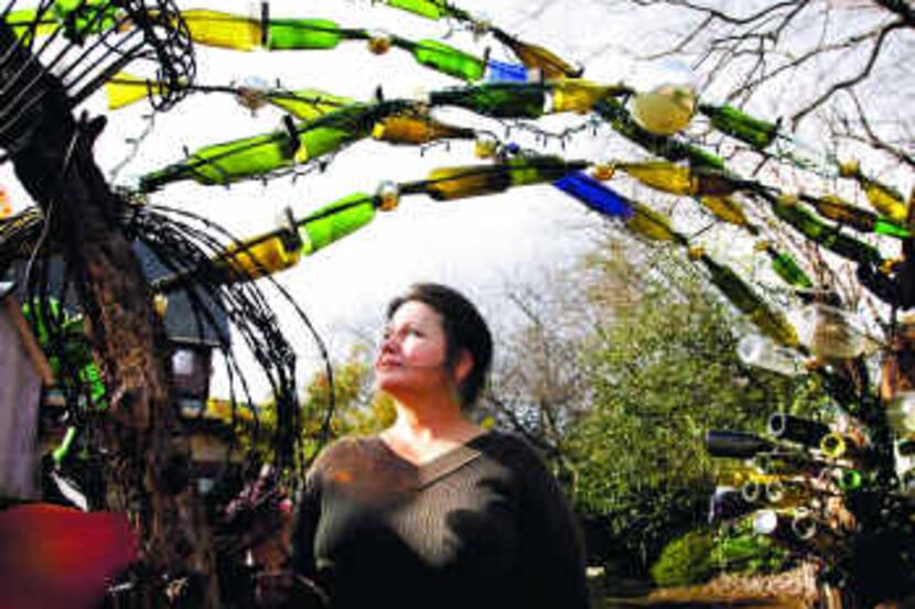  Barbara Dybala, under a bottle arch in her Sunnyvale yard, has been making mosaic garden...