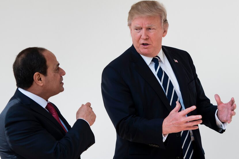 Egypt's President Abdel Fattah al-Sisi (L) and US President Donald Trump walk through the...