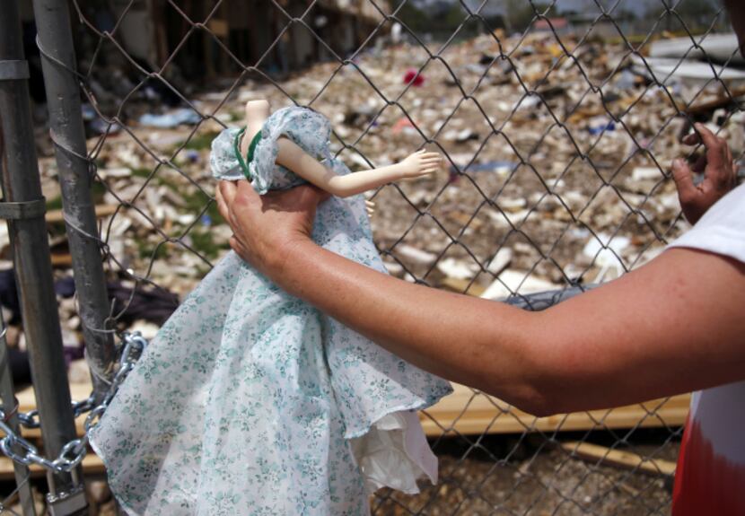 Carol Bare picks up a doll belonging to her sister, Shona Jupe, during a visit to the site...