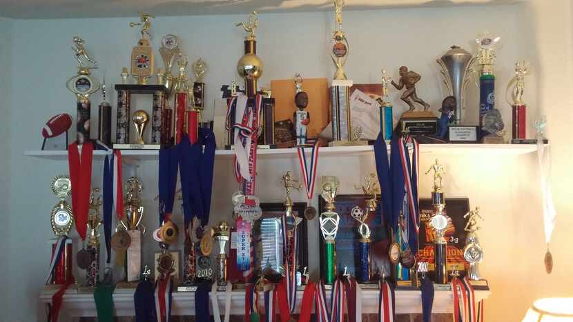 A shelf full of Eno Benjamin and Ubong's trophies in the living room of their house.
