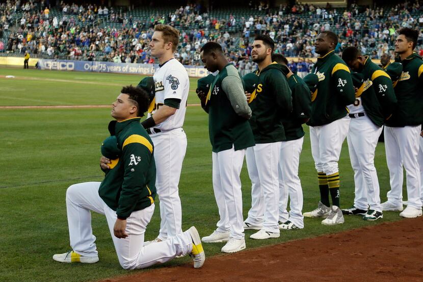Oakland Athletics catcher Bruce Maxwell kneels during the national anthem before the start...