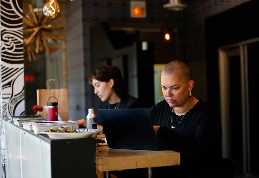 Megan Jeyifo, executive director at Chicago Abortion Fund, right, works on her laptop with...