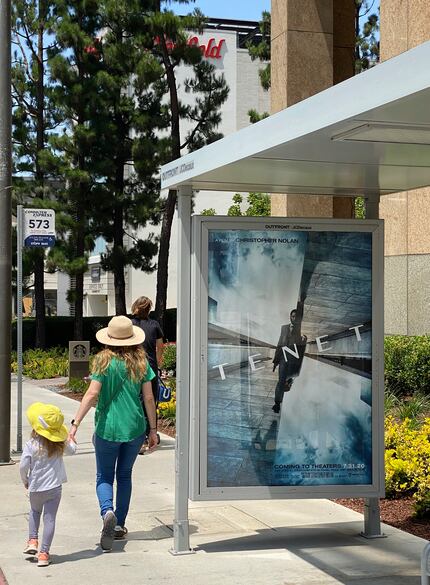 In this June 27, 2020 photo, people walk by a poster promoting the long-awaited Christopher...