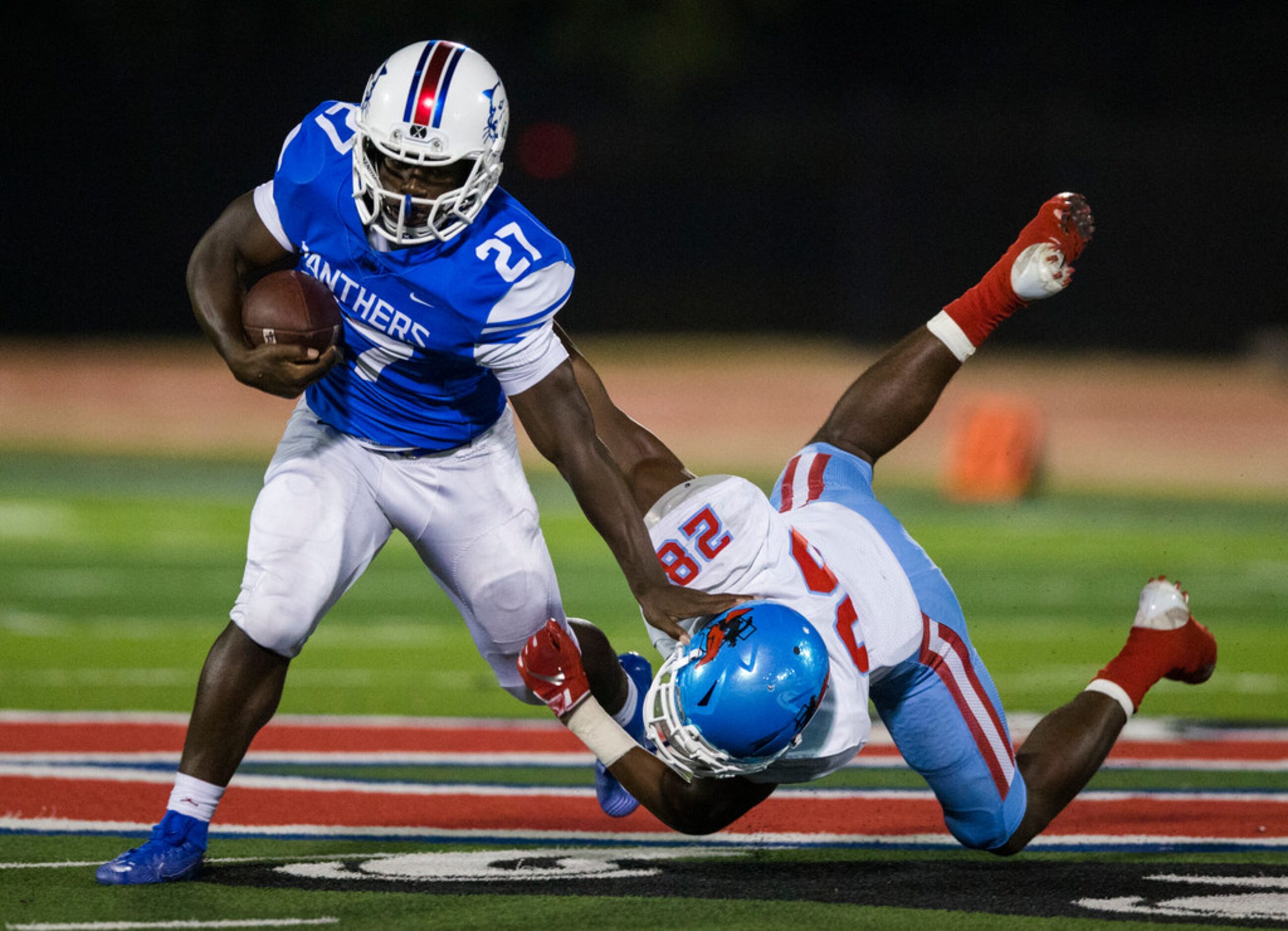 Duncanville running back Couvarris Butler (27) fends off Skyline linebacker Tyrione McDonald...