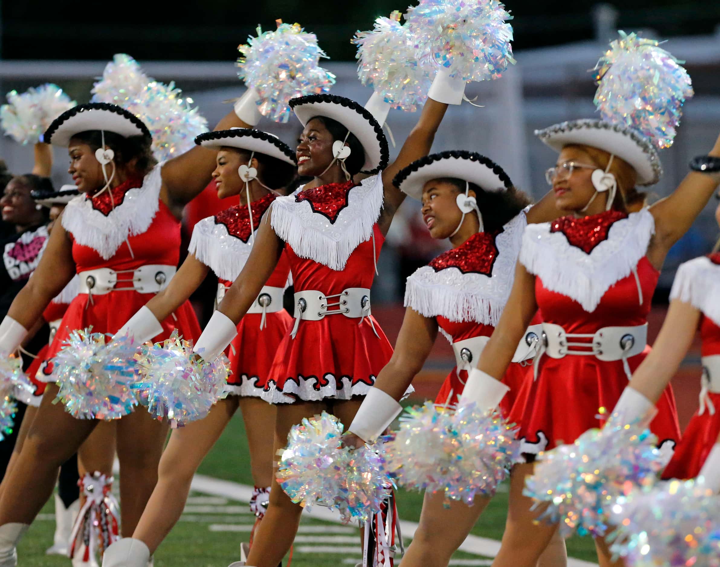 The Mesquite Horn drill team waves poms before the start of the first half of a high school...
